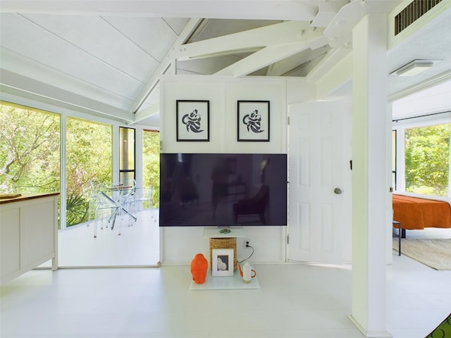 living room with vaulted ceiling with beams