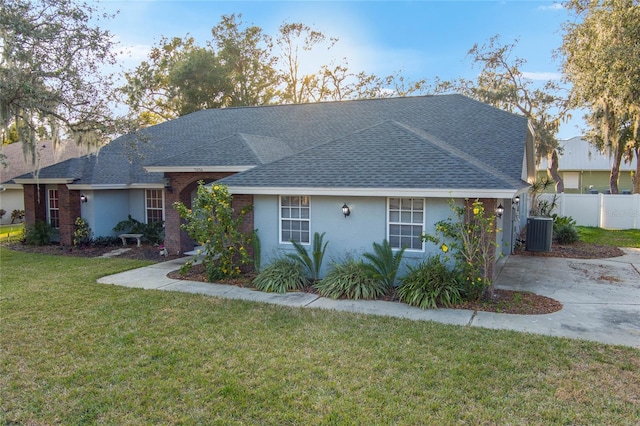 ranch-style house with central AC unit and a front yard