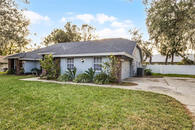 ranch-style home featuring cooling unit, a garage, and a front lawn