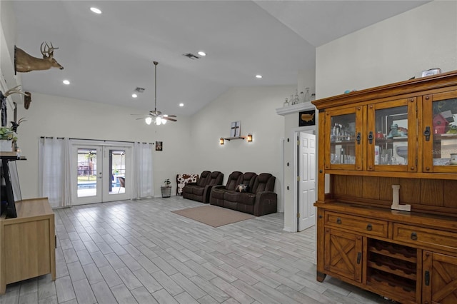 living room with french doors, vaulted ceiling, ceiling fan, and light hardwood / wood-style flooring