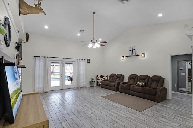 living room with high vaulted ceiling, french doors, ceiling fan, and light wood-type flooring