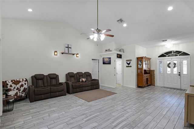 living room with ceiling fan, lofted ceiling, and light hardwood / wood-style flooring