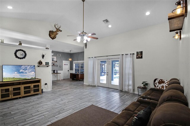 living room with french doors, ceiling fan, and high vaulted ceiling