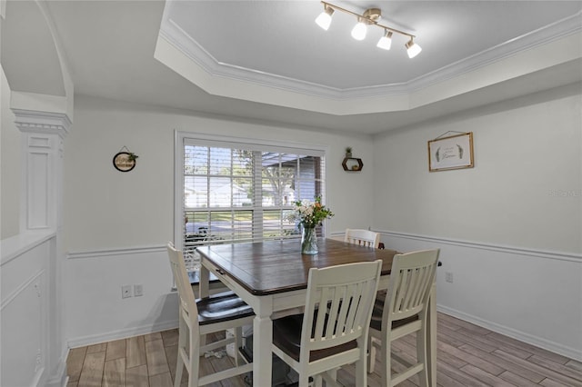 dining room featuring a tray ceiling, ornamental molding, and rail lighting