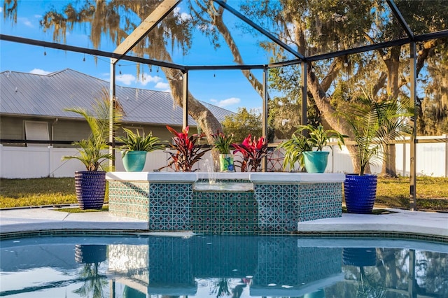 view of swimming pool with pool water feature and glass enclosure