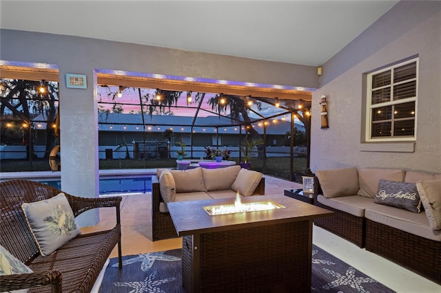 view of patio featuring an outdoor living space with a fire pit and glass enclosure