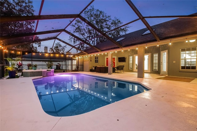 view of swimming pool with outdoor lounge area, glass enclosure, and a patio area