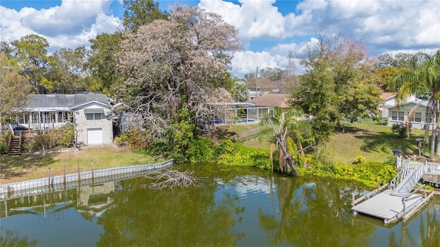 view of dock with a yard and a water view