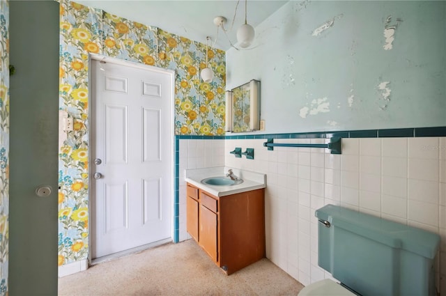 bathroom with vanity, tile walls, and toilet