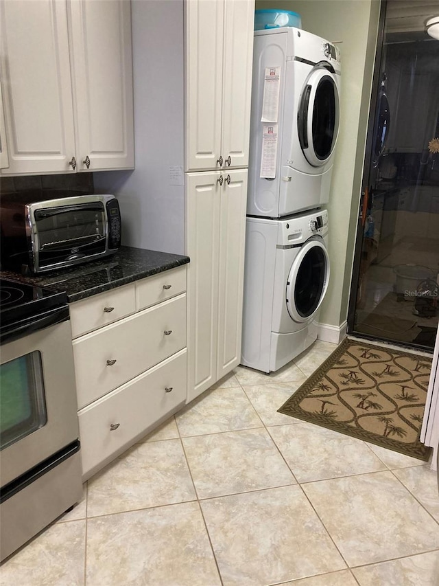 laundry room with stacked washer and dryer and light tile patterned flooring