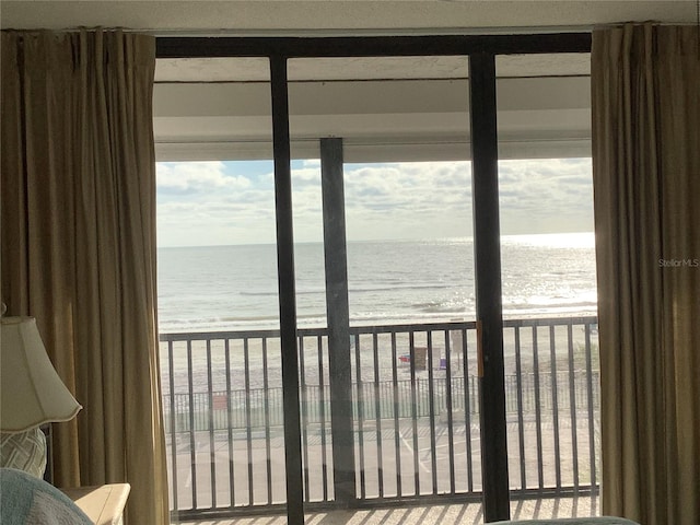 interior space with a water view and a beach view