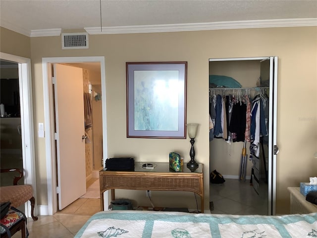 bedroom featuring crown molding, a closet, and light tile patterned flooring