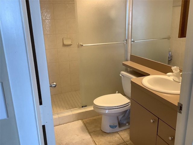 bathroom with vanity, a tile shower, tile patterned floors, and toilet