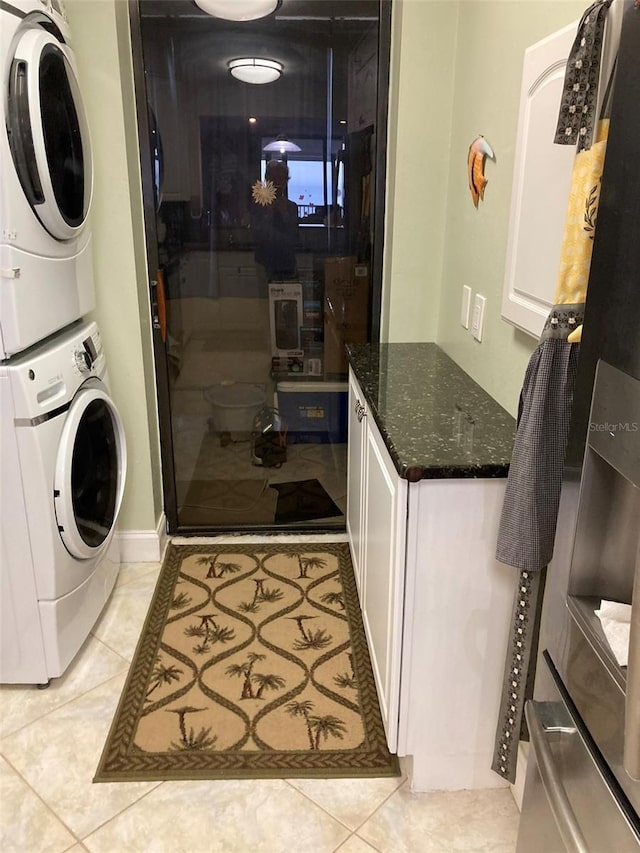 washroom featuring stacked washer and dryer and light tile patterned floors