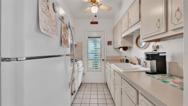 kitchen featuring sink, white appliances, light tile patterned floors, and ceiling fan