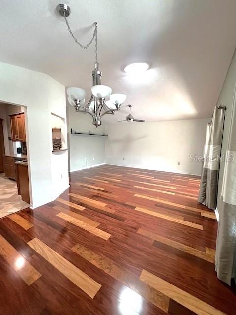 unfurnished dining area featuring hardwood / wood-style floors and ceiling fan with notable chandelier