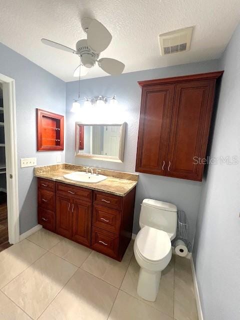 bathroom featuring vanity, tile patterned floors, a textured ceiling, and toilet