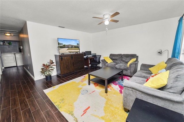 living room featuring ceiling fan, a textured ceiling, and washing machine and clothes dryer