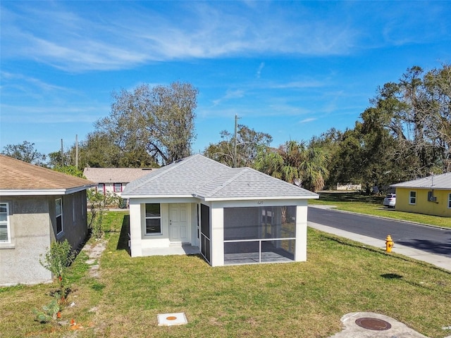 view of front of home with a front lawn and a sunroom