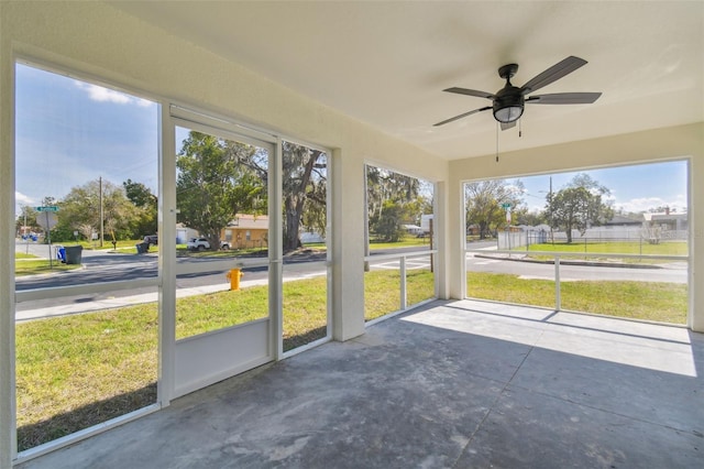 unfurnished sunroom with ceiling fan