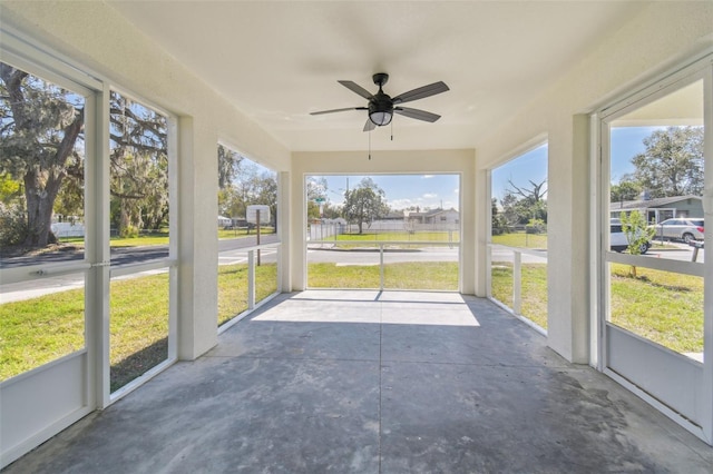 unfurnished sunroom with ceiling fan