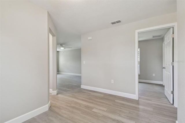 spare room with ceiling fan and light wood-type flooring