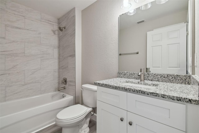 full bathroom featuring vanity, toilet, and tiled shower / bath combo