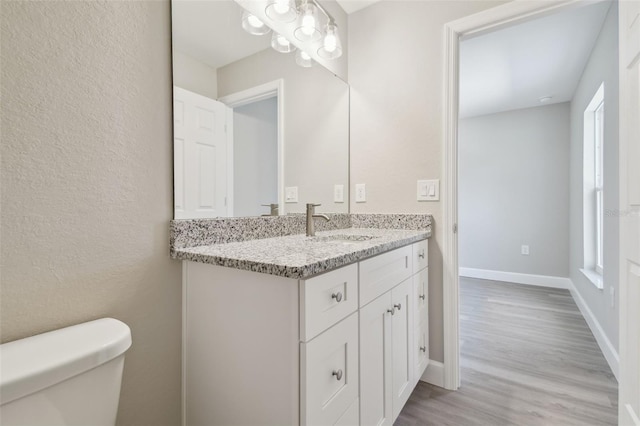 bathroom featuring vanity, hardwood / wood-style floors, and toilet