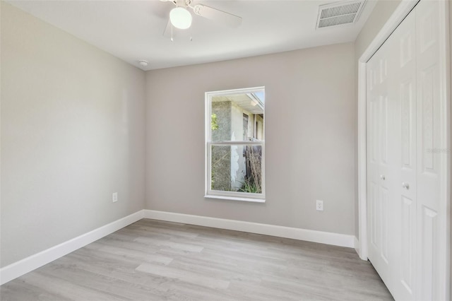 unfurnished bedroom with light hardwood / wood-style flooring, a closet, and ceiling fan