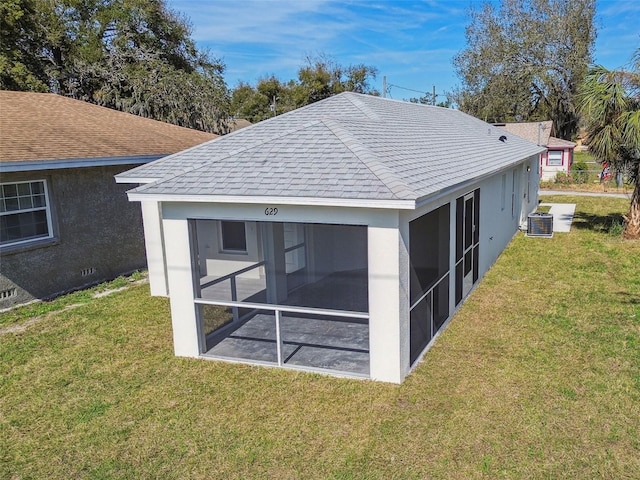 view of outbuilding with cooling unit, a lawn, and a sunroom