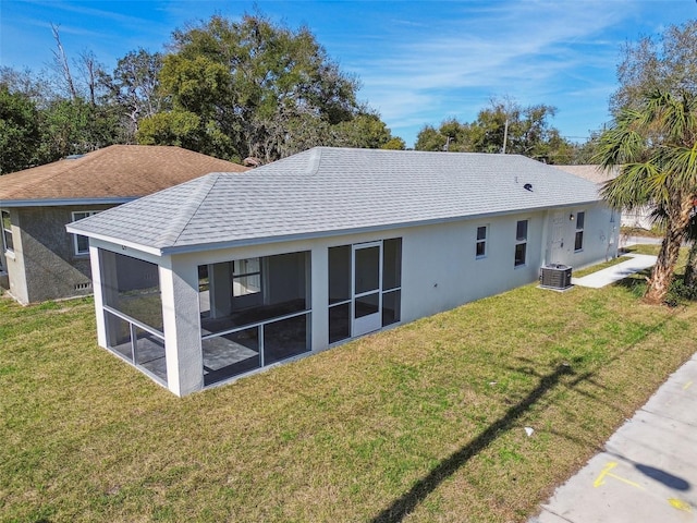 rear view of property featuring cooling unit, a yard, and a sunroom