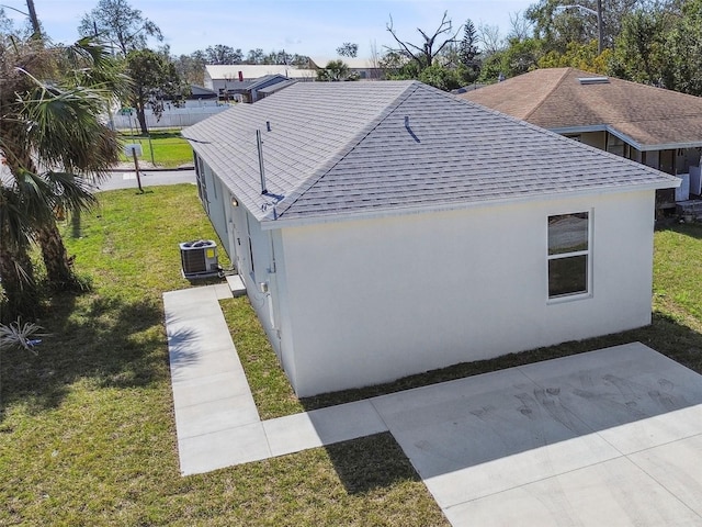 view of side of property featuring a yard and central AC unit