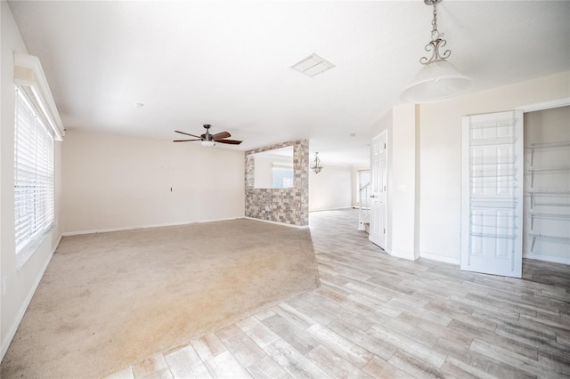 unfurnished living room featuring light colored carpet and ceiling fan