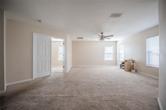 carpeted empty room with a textured ceiling and ceiling fan