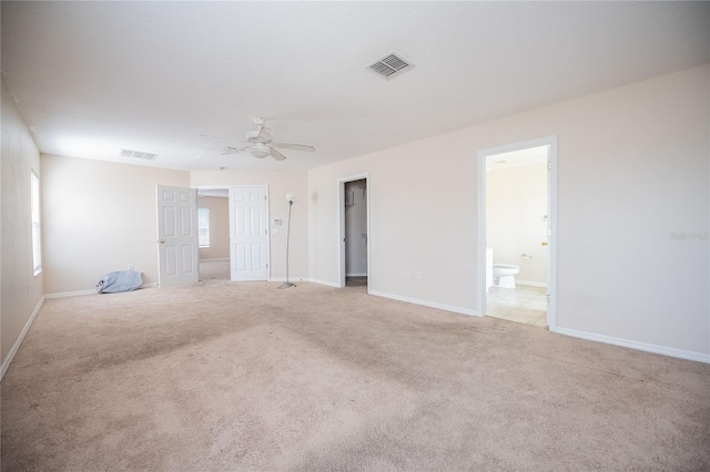 spare room with visible vents, light colored carpet, and baseboards