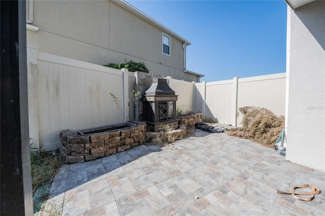 view of patio / terrace with an outdoor fireplace and a fenced backyard