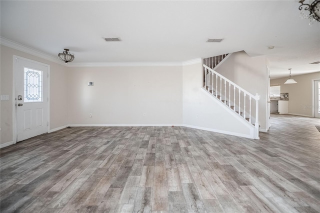 unfurnished living room featuring stairway, visible vents, and wood finished floors