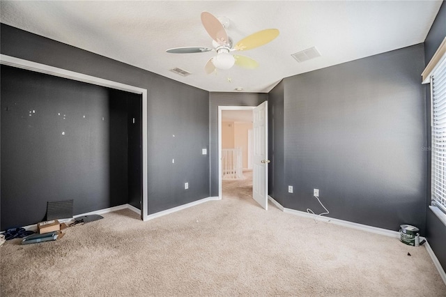 unfurnished bedroom with a ceiling fan, baseboards, visible vents, and carpet floors