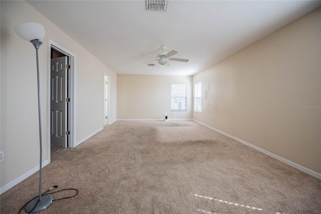 unfurnished room with baseboards, visible vents, carpet floors, and ceiling fan