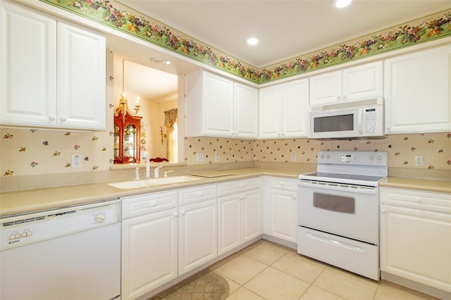 kitchen with sink, white cabinetry, tasteful backsplash, light tile patterned floors, and white appliances