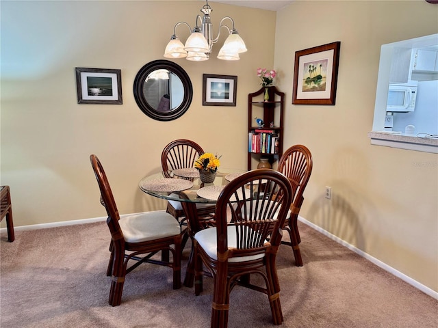 dining area with a chandelier and carpet