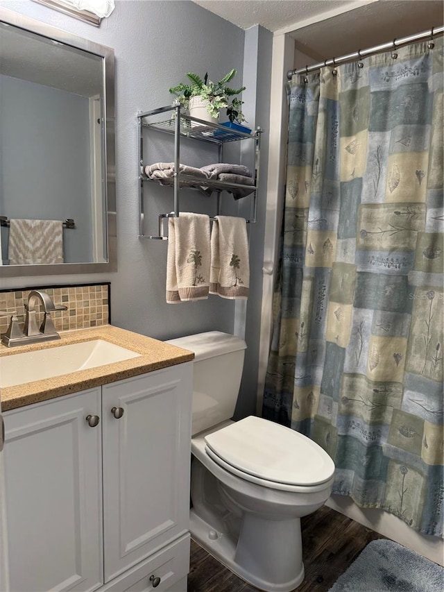 bathroom with curtained shower, tasteful backsplash, wood-type flooring, vanity, and toilet