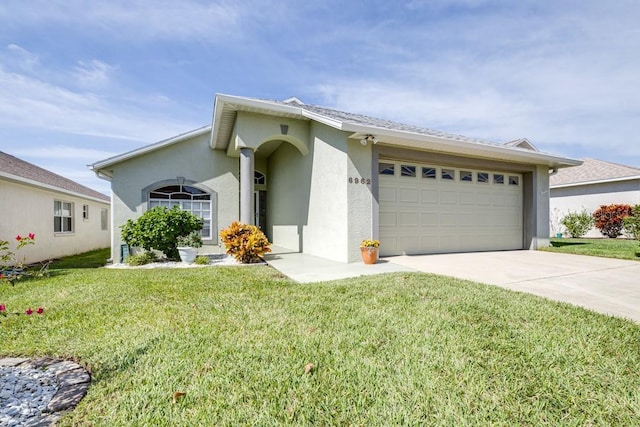 single story home featuring a garage and a front lawn