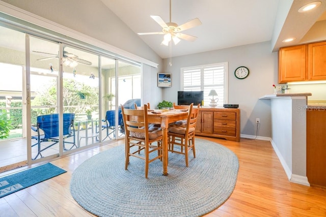 dining area with vaulted ceiling, ceiling fan, and light wood-type flooring