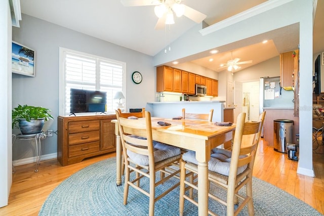 dining space featuring ceiling fan, lofted ceiling, and light hardwood / wood-style floors