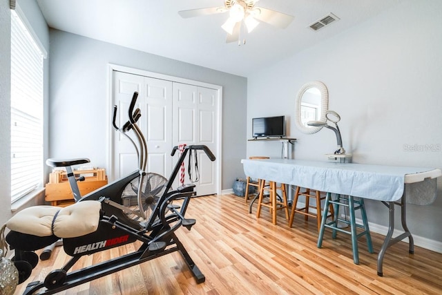 exercise room featuring ceiling fan, plenty of natural light, and light hardwood / wood-style floors