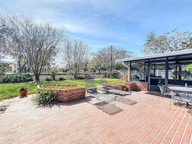 view of patio / terrace featuring a sunroom and an outdoor fire pit