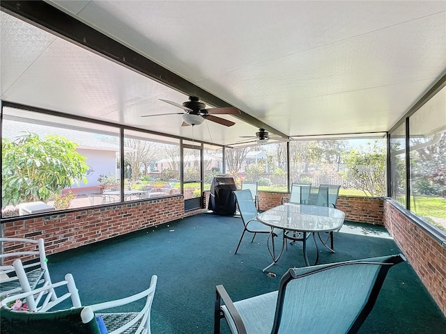 unfurnished sunroom featuring beam ceiling