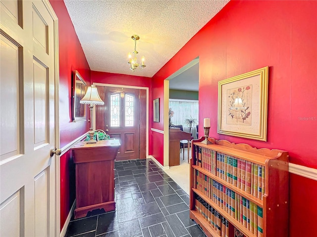 foyer entrance featuring a textured ceiling and a chandelier