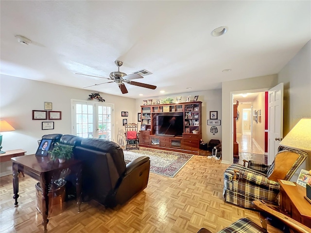 living room with french doors, ceiling fan, and light parquet flooring